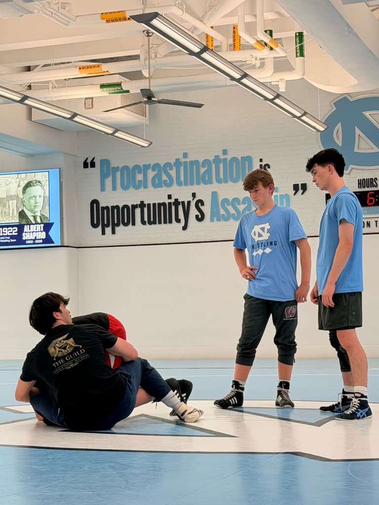 Guild coach working with athletes on the mat